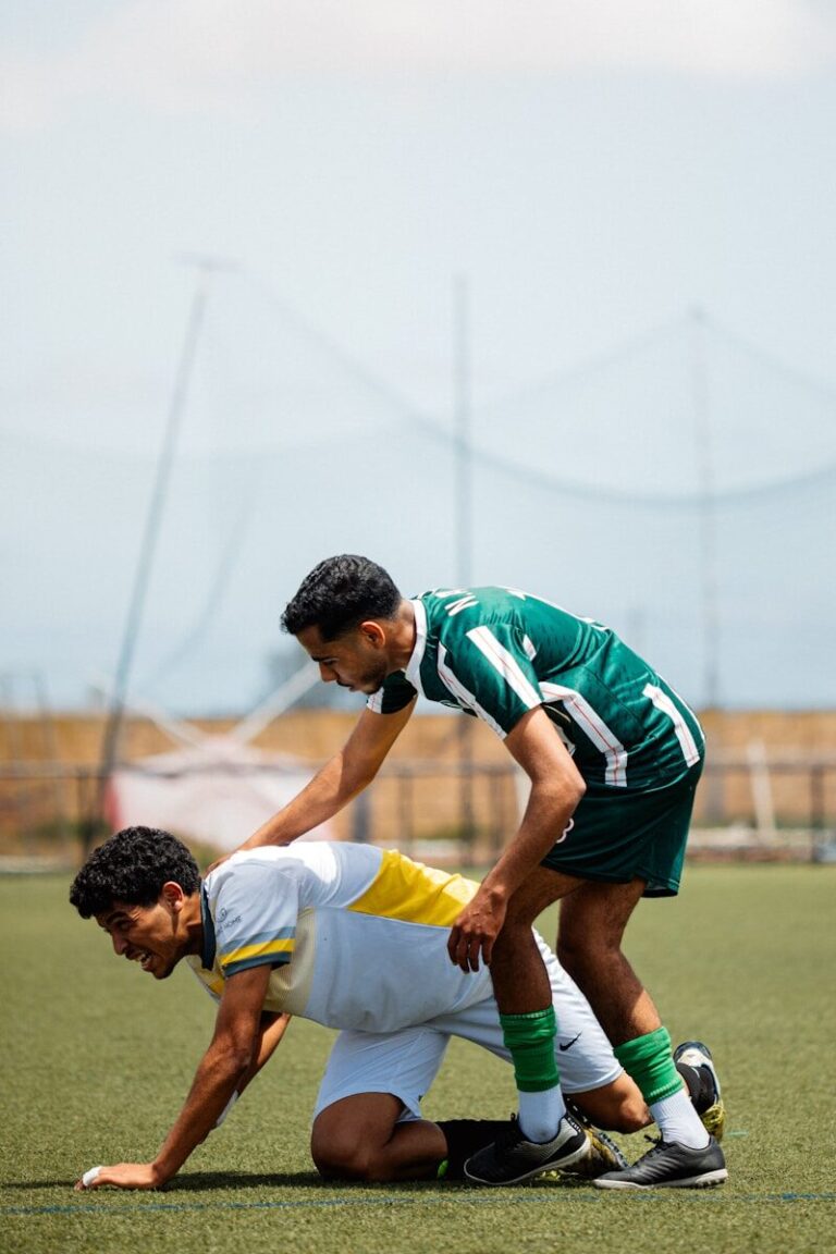 A soccer player is helping a teammate.
